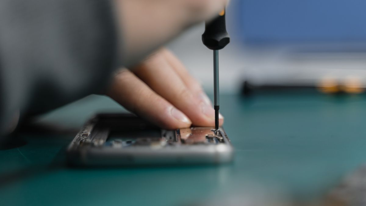 Pièces détachées et outils de réparation de téléphone posés sur un plan de travail