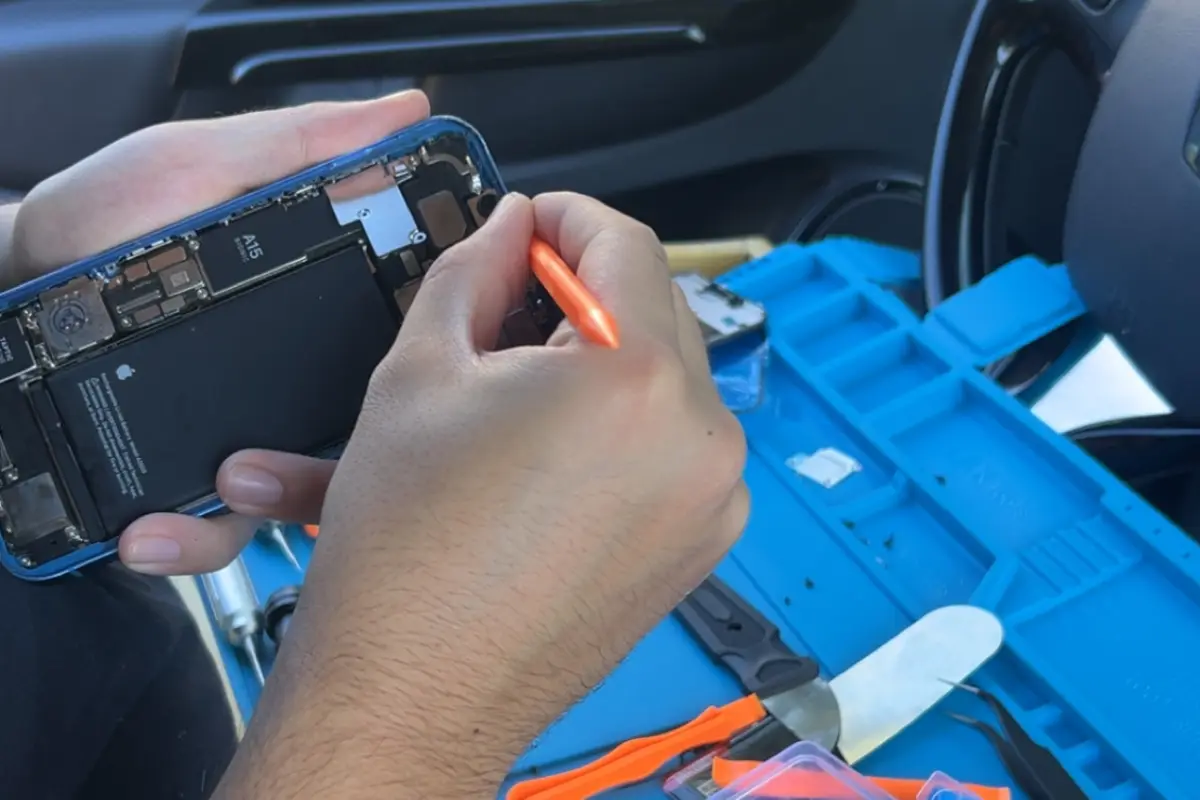 Réparation d'un smartphone dans l'atelier mobile NinjaPhone installé dans le véhicule