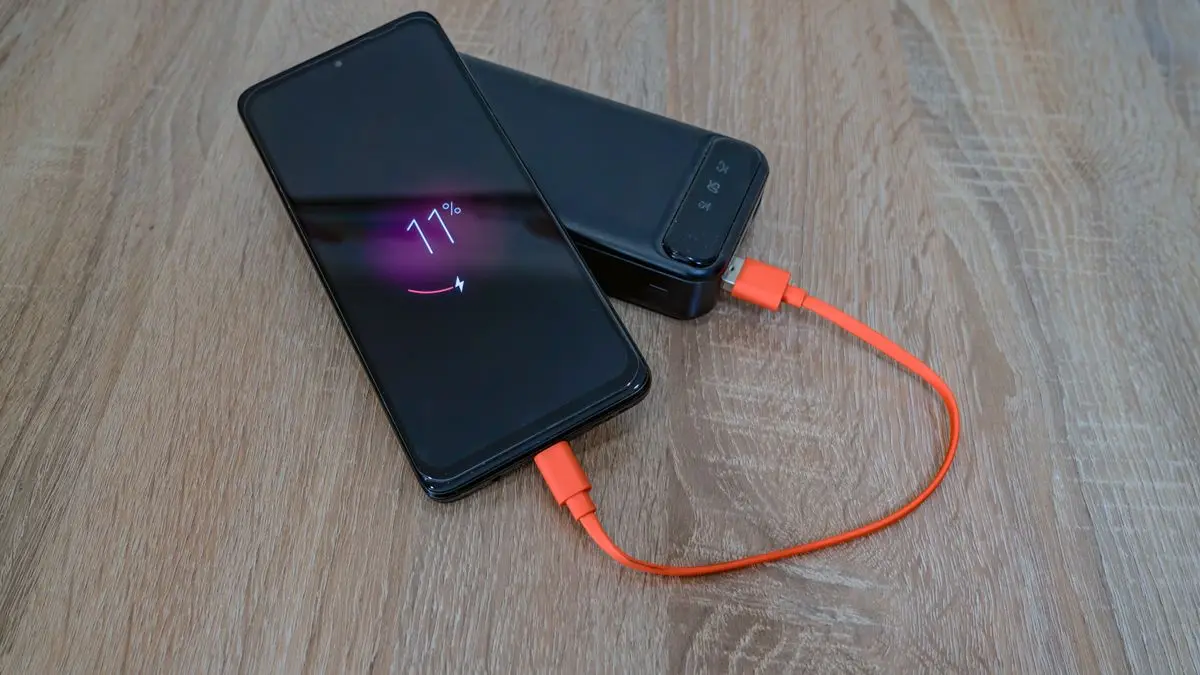 Smartphone en charge dont la batterie usée se décharge trop vite