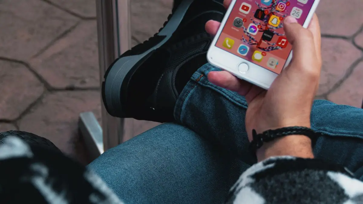 iPhone reconditionné tenu en main pendant la vérification de ses fonctions