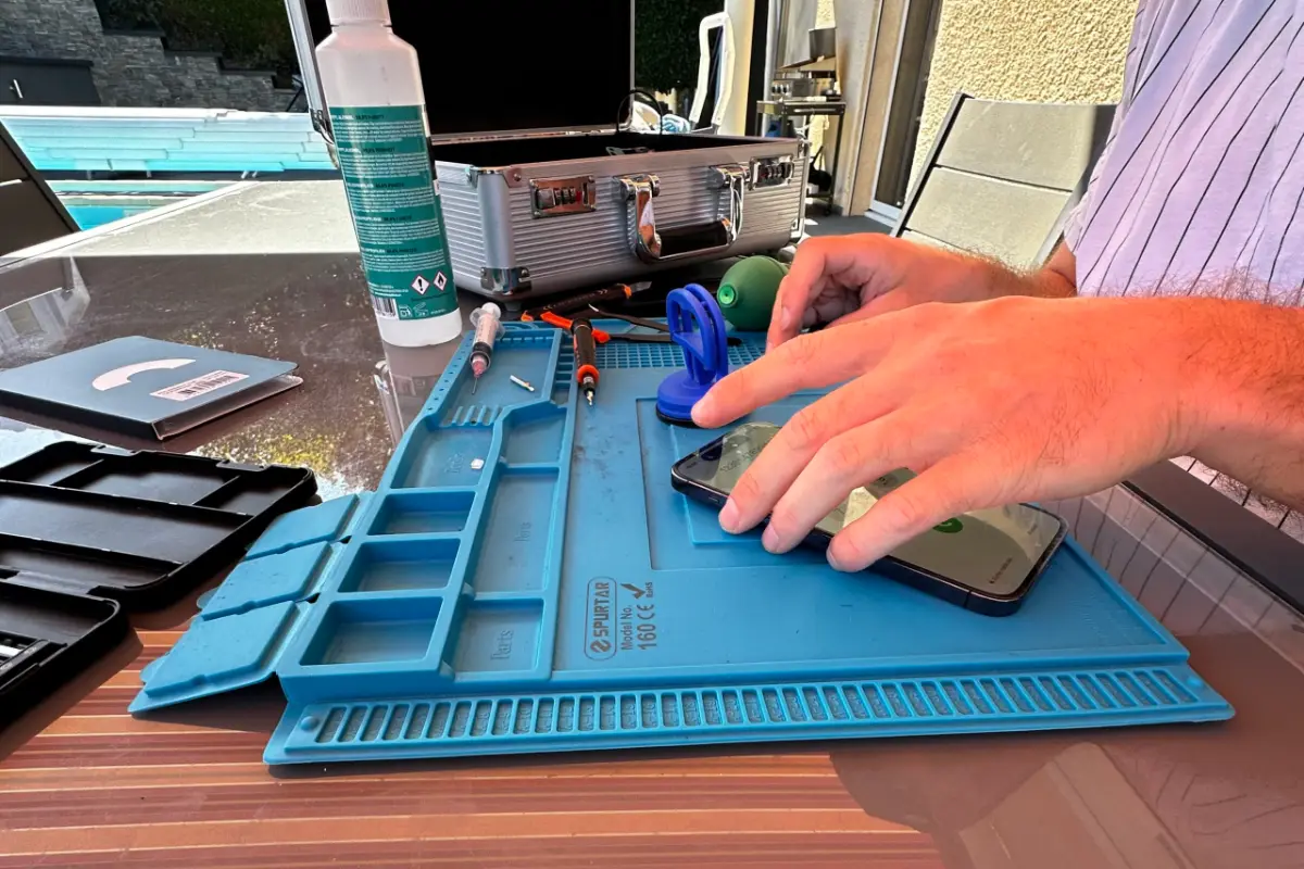Réparation d'un téléphone à domicile par NinjaPhone, sur une table en extérieur chez le client